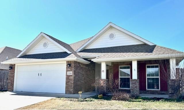 view of front of house with a shingled roof, brick siding, driveway, and an attached garage