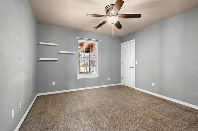 empty room with carpet floors, ceiling fan, and baseboards