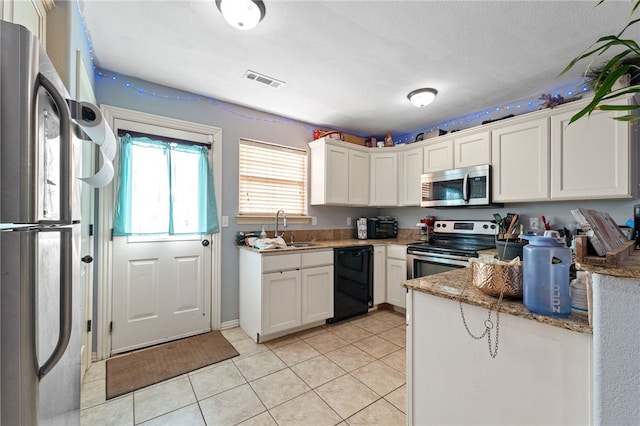 kitchen featuring light tile patterned floors, visible vents, white cabinets, stainless steel appliances, and a sink