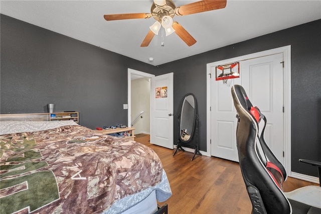 bedroom featuring wood finished floors, a ceiling fan, and baseboards