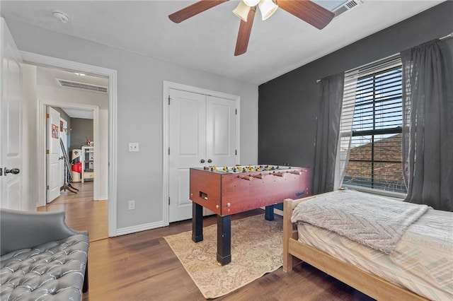 bedroom featuring a closet, wood finished floors, visible vents, and baseboards