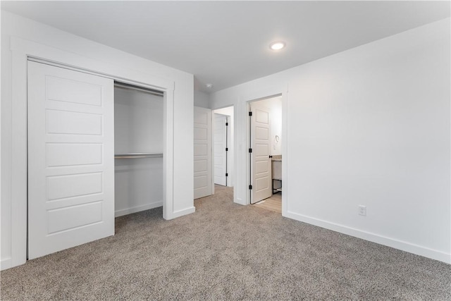 unfurnished bedroom with carpet floors, a closet, and baseboards