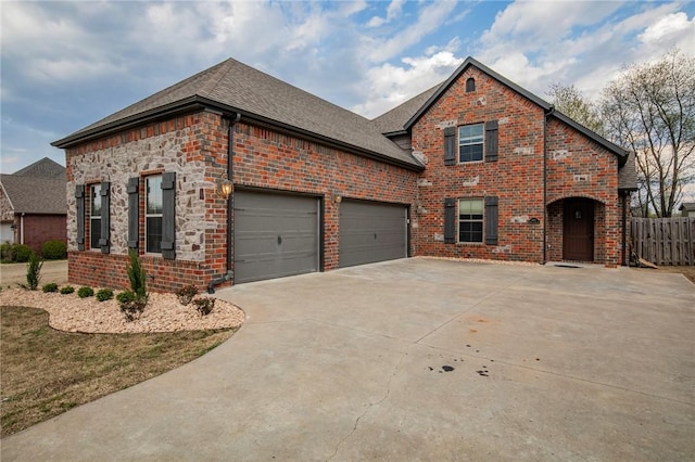 view of front of house featuring driveway, an attached garage, fence, and brick siding