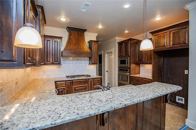 kitchen featuring visible vents, light stone counters, ornamental molding, stainless steel appliances, and premium range hood