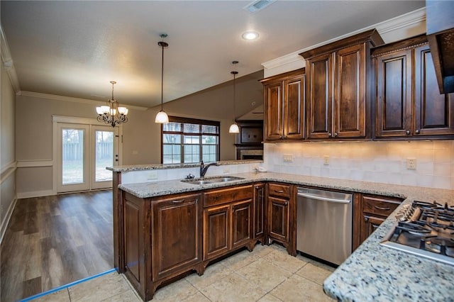 kitchen featuring a peninsula, appliances with stainless steel finishes, backsplash, and a sink