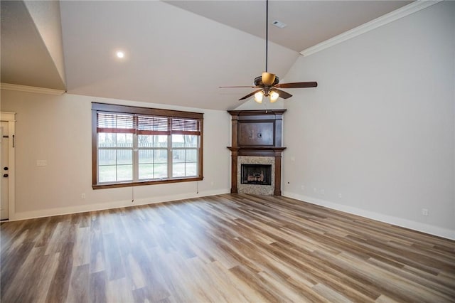 unfurnished living room featuring crown molding, a fireplace, baseboards, and wood finished floors