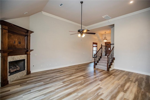 living area featuring a fireplace, stairway, vaulted ceiling, light wood-type flooring, and baseboards