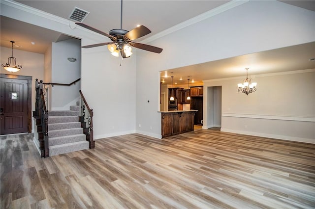 unfurnished living room featuring ornamental molding, visible vents, stairway, and light wood finished floors