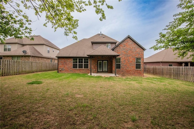 3601 SW Willowbrook Rd, Bentonville, AR 72713 - rear view of house with a fenced backyard, roof with shingles, a patio, a lawn, and brick siding