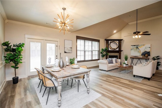 3601 SW Willowbrook Rd, Bentonville, AR 72713 - dining area with vaulted ceiling, a chandelier, light wood-style floors, a fireplace, and baseboards