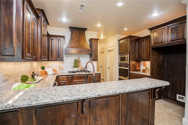 3601 SW Willowbrook Rd, Bentonville, AR 72713 - kitchen with a peninsula, visible vents, custom range hood, light stone countertops, and appliances with stainless steel finishes