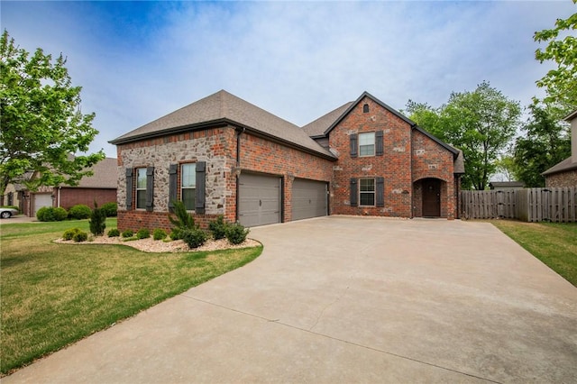 3601 SW Willowbrook Rd, Bentonville, AR 72713 - french country home featuring driveway, fence, a front yard, a garage, and brick siding