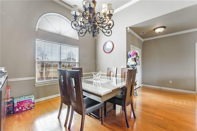 dining area with baseboards, visible vents, ornamental molding, wood finished floors, and an inviting chandelier