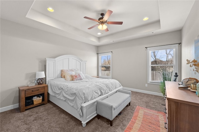 carpeted bedroom with ceiling fan, baseboards, a raised ceiling, and recessed lighting