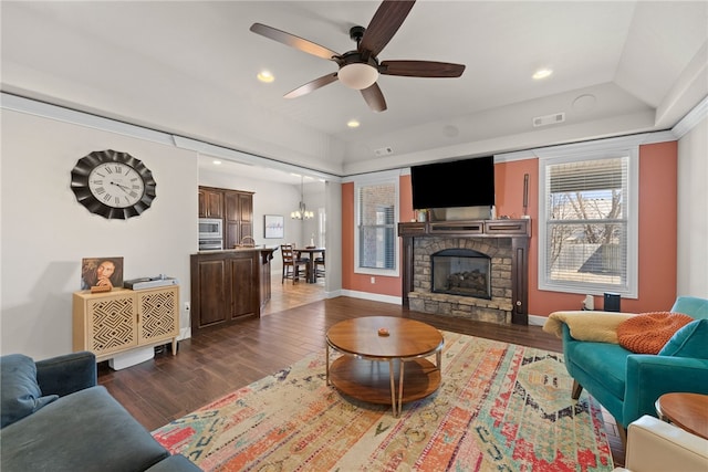 living room with a stone fireplace, recessed lighting, wood finished floors, visible vents, and baseboards