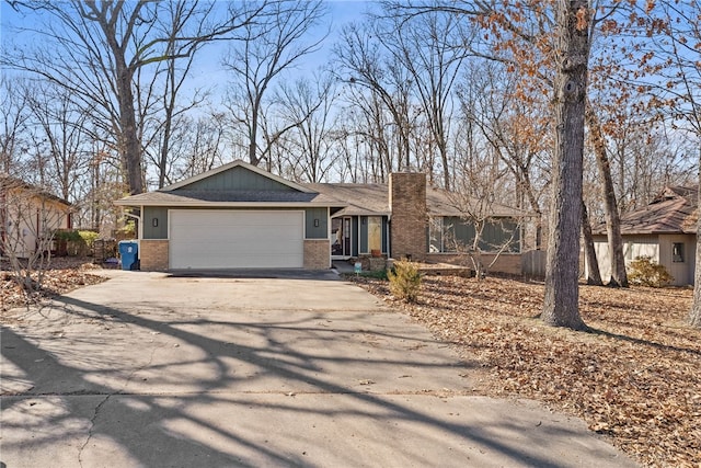 ranch-style house featuring a garage, concrete driveway, and brick siding