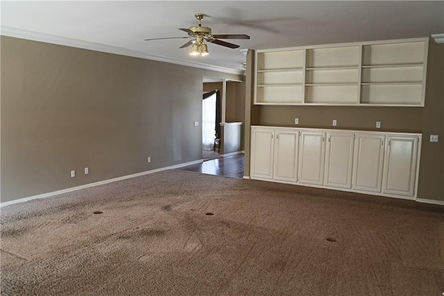 unfurnished living room featuring baseboards, ornamental molding, dark colored carpet, and a ceiling fan