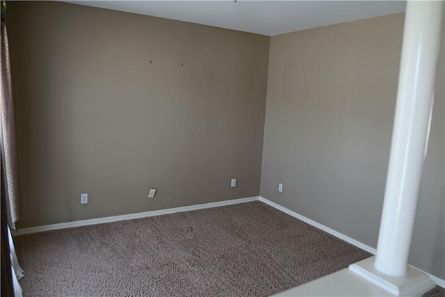 carpeted spare room featuring baseboards