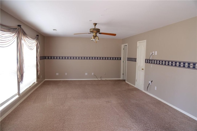 empty room with ceiling fan, carpet, visible vents, and baseboards