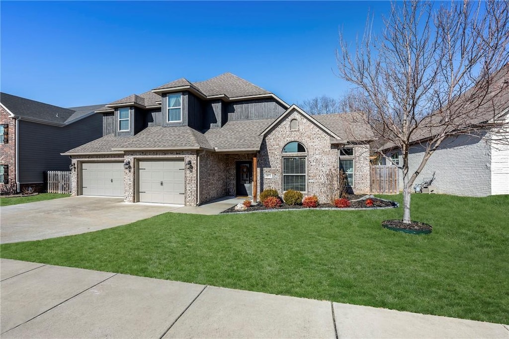 view of front of property featuring brick siding, fence, driveway, roof with shingles, and a front yard