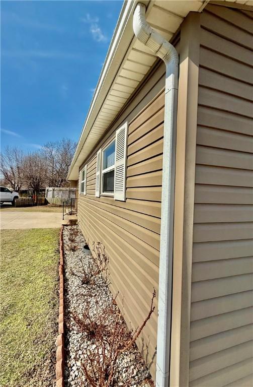 view of side of home featuring a yard and fence