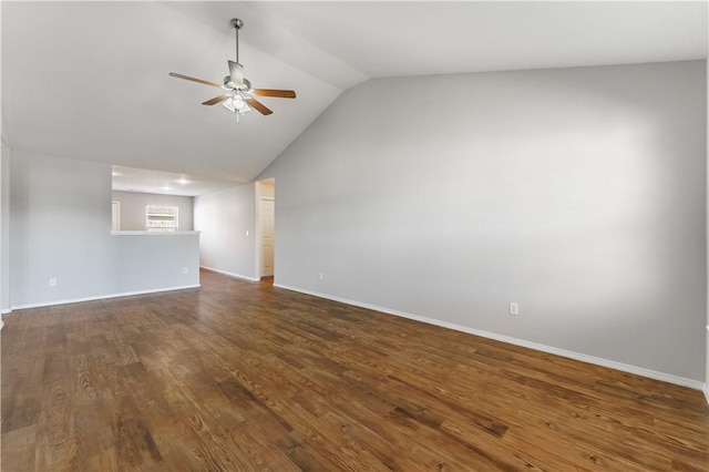 spare room featuring dark wood-style floors, lofted ceiling, baseboards, and a ceiling fan