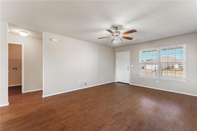 unfurnished room with ceiling fan, baseboards, and dark wood-type flooring