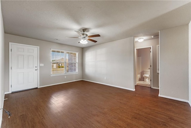 empty room with dark wood-style flooring, ceiling fan, and baseboards