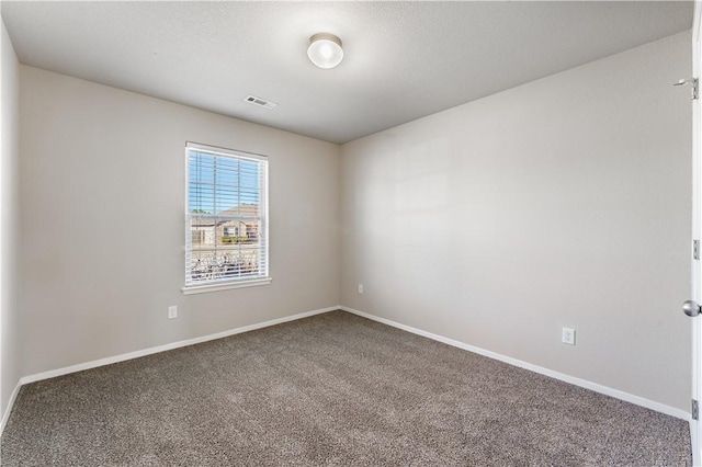 carpeted empty room with visible vents and baseboards