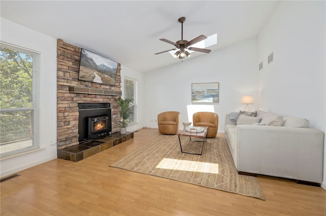 living area with visible vents, vaulted ceiling, and wood finished floors