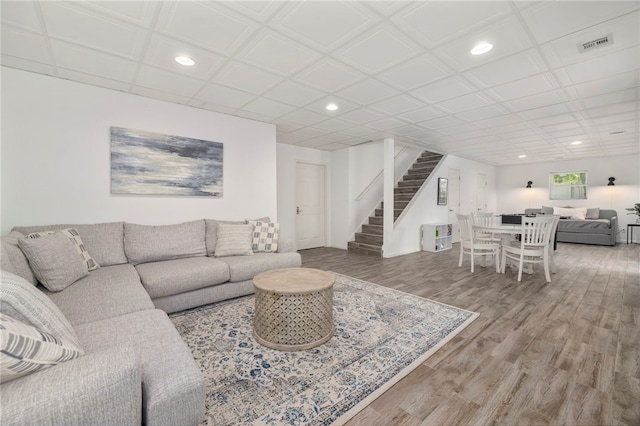 living room featuring stairs, visible vents, wood finished floors, and recessed lighting