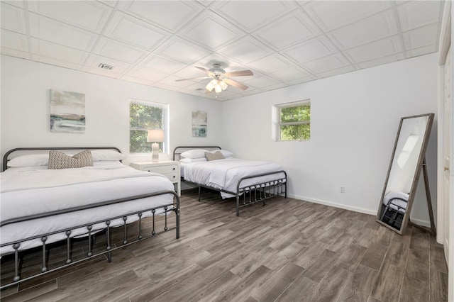 bedroom featuring an ornate ceiling, multiple windows, and baseboards