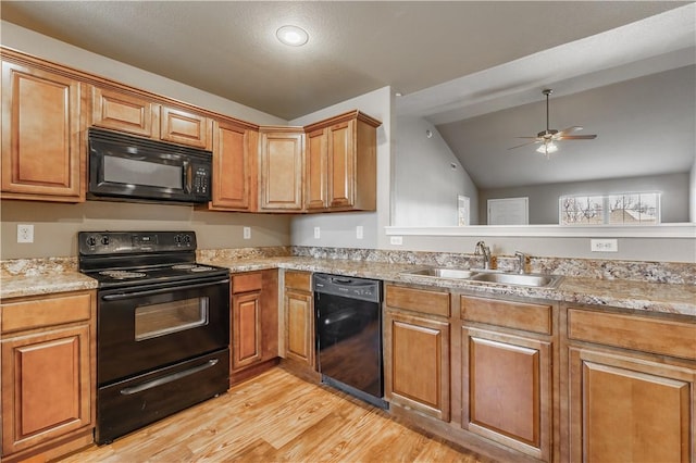 kitchen with a ceiling fan, light wood-style floors, lofted ceiling, black appliances, and a sink