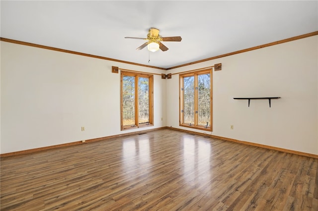 spare room featuring baseboards, wood finished floors, and ornamental molding