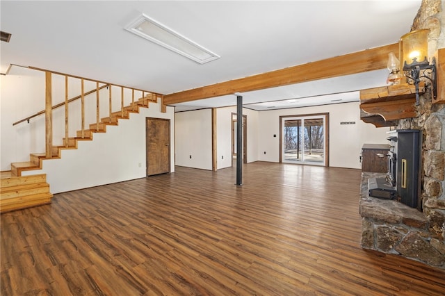 unfurnished living room with stairs, wood finished floors, and beamed ceiling