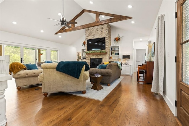 living room with a ceiling fan, wood finished floors, a fireplace, high vaulted ceiling, and recessed lighting