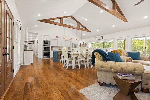 living room featuring a healthy amount of sunlight, high vaulted ceiling, dark wood-style flooring, and recessed lighting