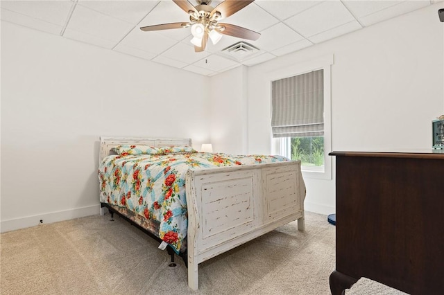 carpeted bedroom featuring baseboards, visible vents, ceiling fan, and a drop ceiling