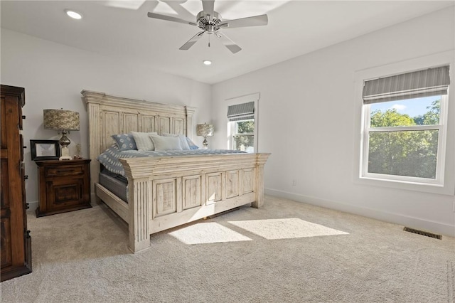 bedroom with baseboards, multiple windows, visible vents, and light colored carpet