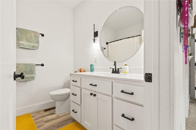 full bathroom with toilet, wood finished floors, visible vents, vanity, and baseboards