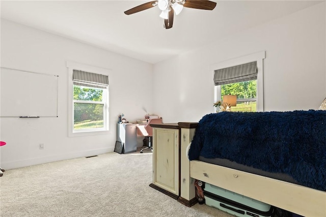 bedroom with carpet floors, multiple windows, ceiling fan, and baseboards