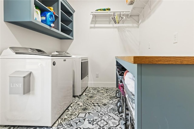 clothes washing area featuring laundry area, independent washer and dryer, and baseboards