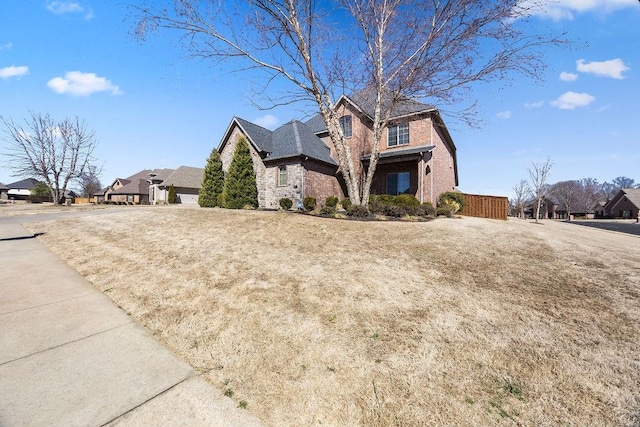 view of front of home featuring stone siding, brick siding, and a residential view