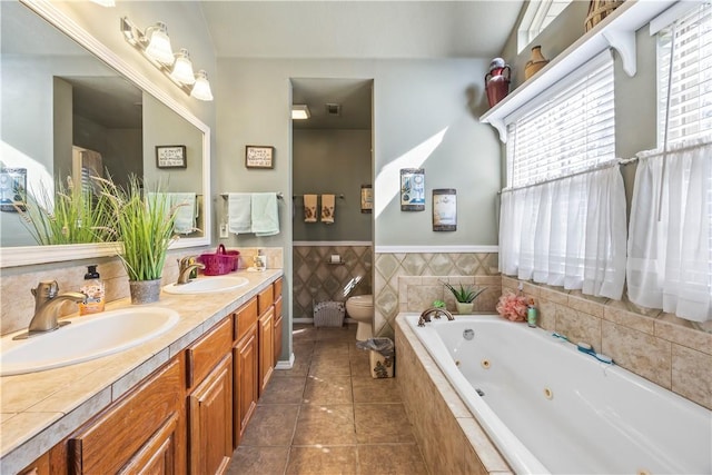 full bathroom with tile patterned flooring, toilet, a sink, and a tub with jets