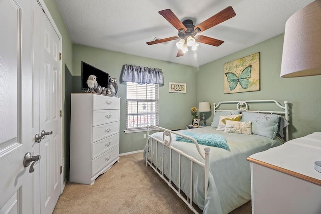 bedroom featuring light colored carpet, ceiling fan, and baseboards