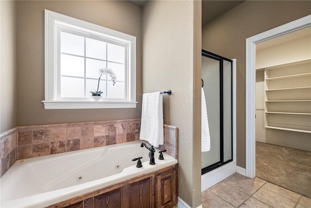 full bathroom with a jetted tub, a shower stall, and tile patterned floors