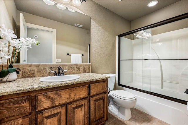 bathroom with toilet, a textured wall, vanity, and visible vents