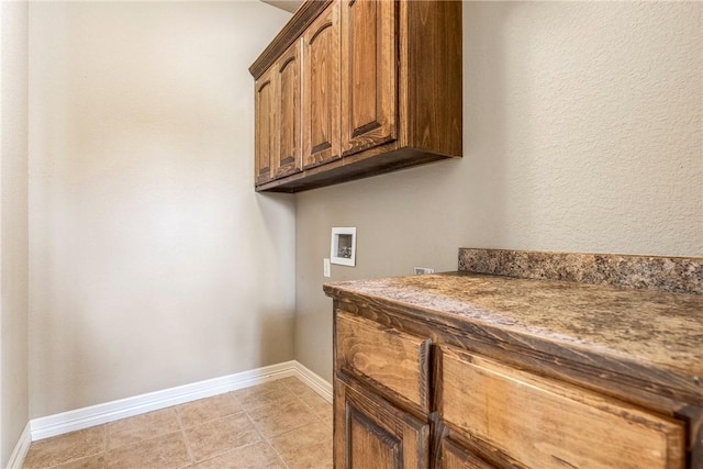 laundry room featuring cabinet space, hookup for a washing machine, baseboards, and light tile patterned flooring