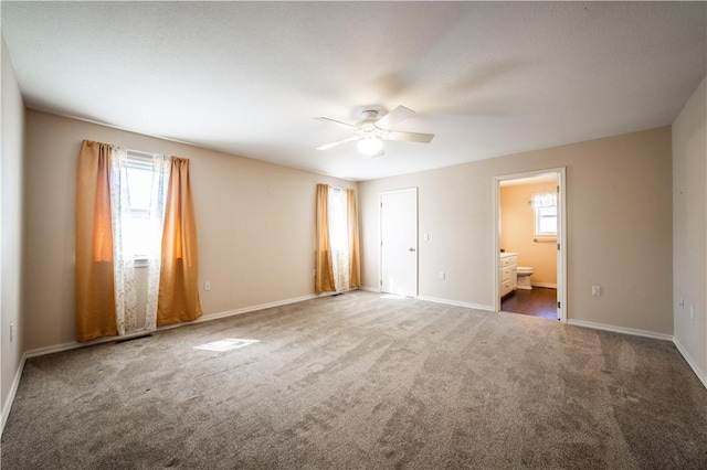 unfurnished bedroom with ensuite bath, carpet, baseboards, and ceiling fan