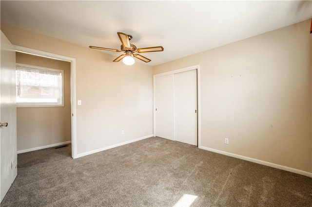 unfurnished bedroom with a closet, carpet flooring, ceiling fan, and baseboards